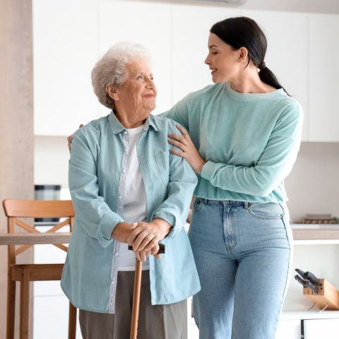 Woman helping an elderly woman walk