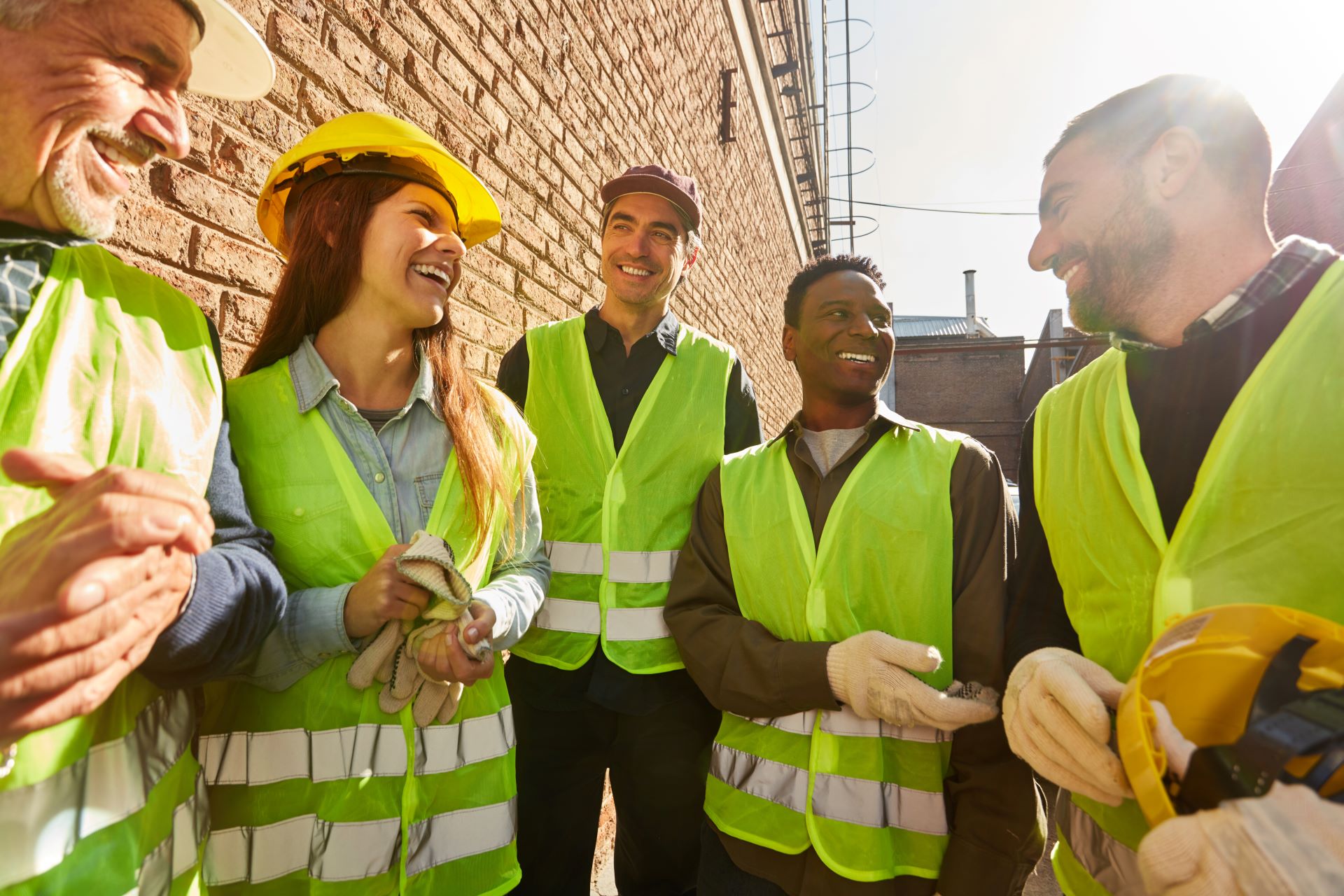 Group of workers in reflective vests enjoying conversation