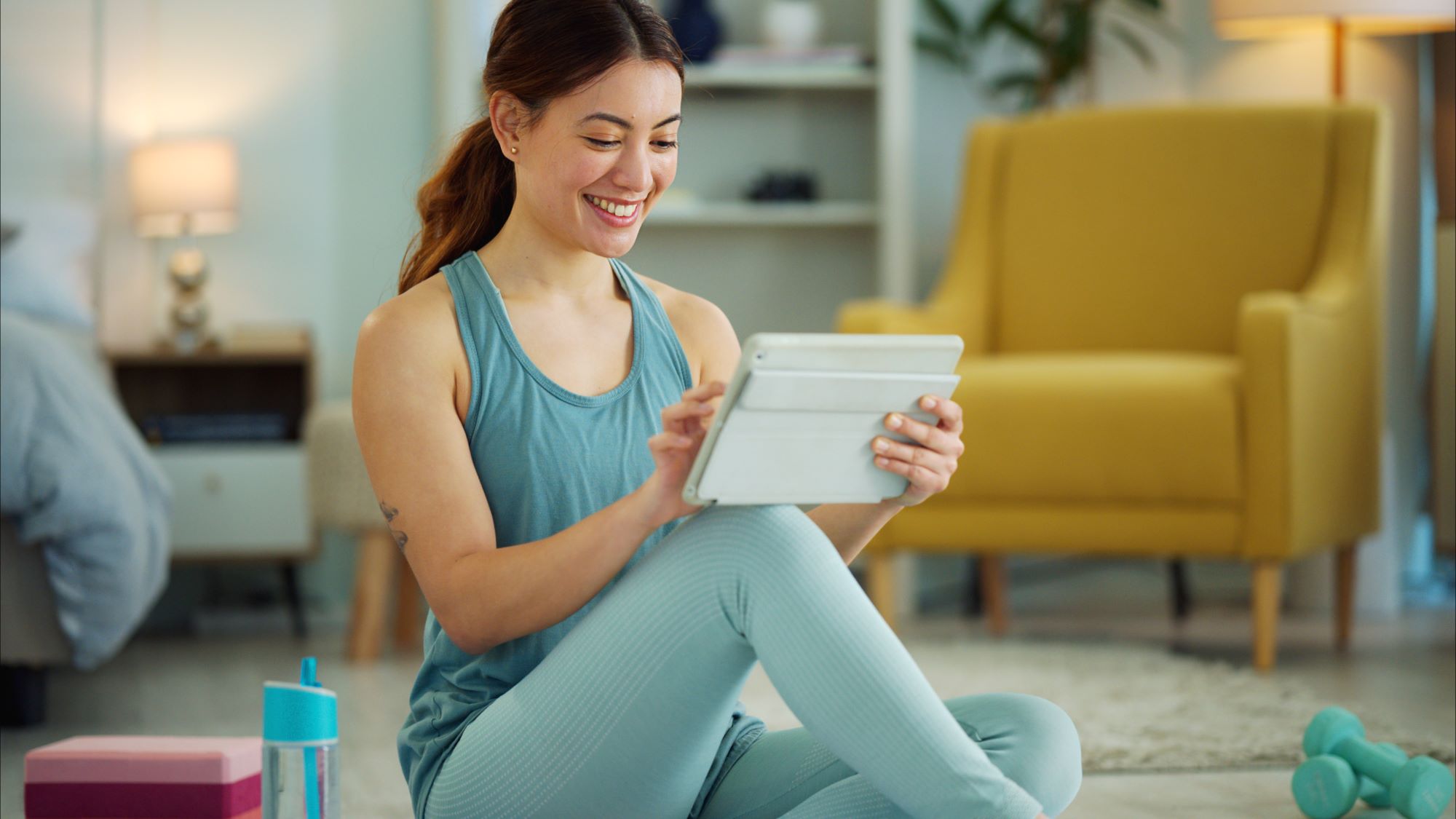 Woman prepares fitness routine using a tablet