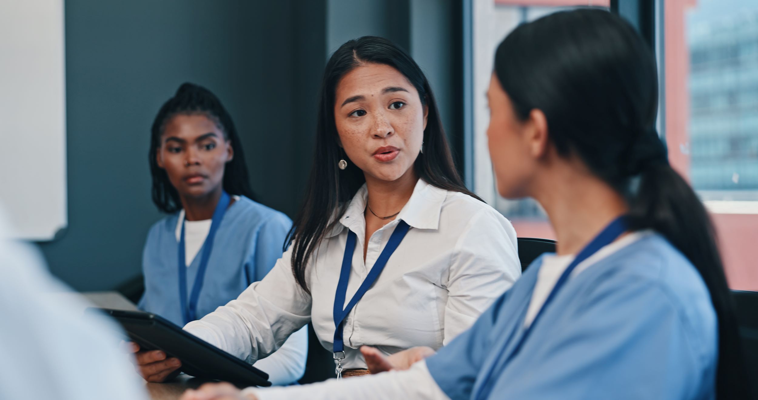 Three female healthcare workers hold a meeting