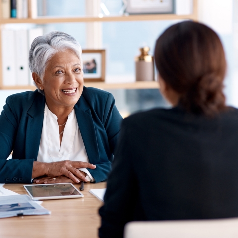 Smiling woman sitting across the desk from her employee