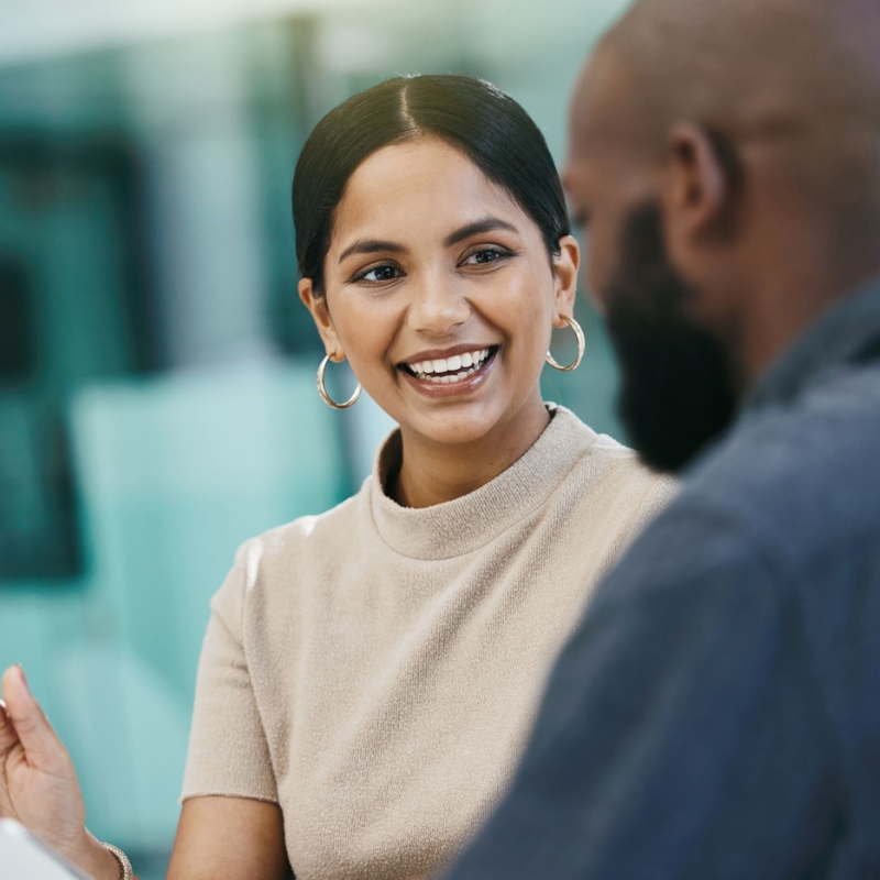 Smiling male with a clipboard listens to a female