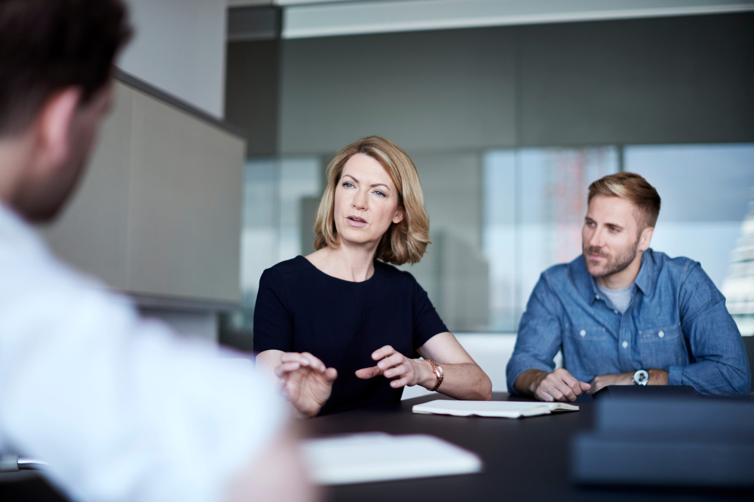 Group of three people hold a serious conversation